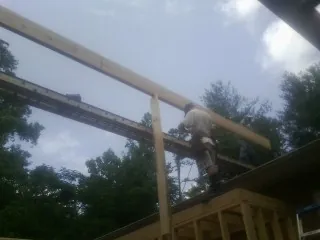 Carpenter setting a ridge beam over a new addition frame — Ice Dam Removal by Roofing Brothers in Saint Charles