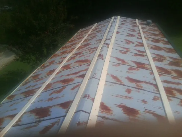Rusted metal roof panels with new wood purlins before replacement — Storm Damage Roof Repair in Saint Charles by Roofing Brothers