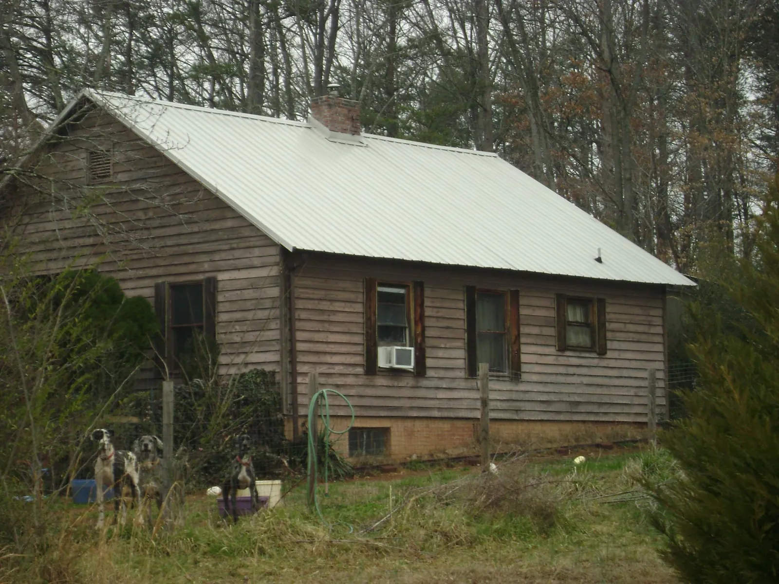 White metal roof on an old wood sided farmhouse, from a Metal Roof Installation job in Saint Charles